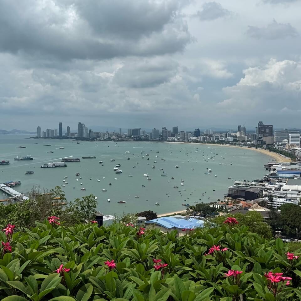 Blick über die Bucht von Pattaya Aussicht auf die Bucht von Pattaya mit Meer, Booten, Küstenlinie und Stadtansicht unter bewölktem Himmel