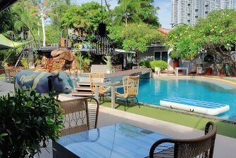 Entspannung pur in Pattayas Unterkünften Poolbereich mit Liegen in tropischer Anlage – typisch für Hotels und Unterkünfte in Pattaya