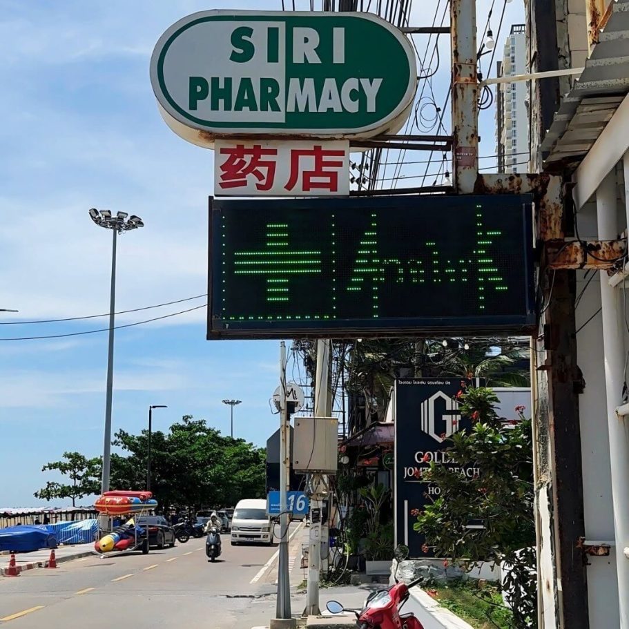 Siri Apotheke in Jomtien – Schnelle Hilfe bei Beschwerden Eingang und Leuchtschild der Siri Pharmacy in Jomtien an einer sonnigen Hauptstraße