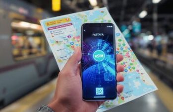 Reiseplanung mit Smartphone und Karte – Unterwegs in Thailand Eine Hand hält ein Smartphone und eine Karte an einem Bahnhof – digitale Reiseplanung in Thailand.