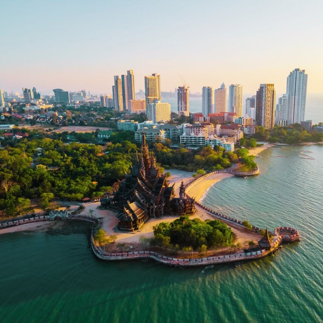 Sanctuary of Truth in Pattaya, Thailand – Ein beeindruckender Holztempel am Meer mit der Skyline von Pattaya im Hintergrund.