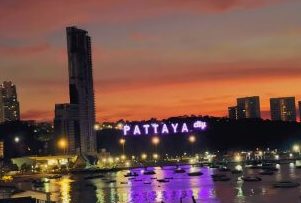 Sundowner mit Ausblick über Pattaya Blick von einer Rooftop-Bar auf das Pattaya City Sign bei Sonnenuntergang