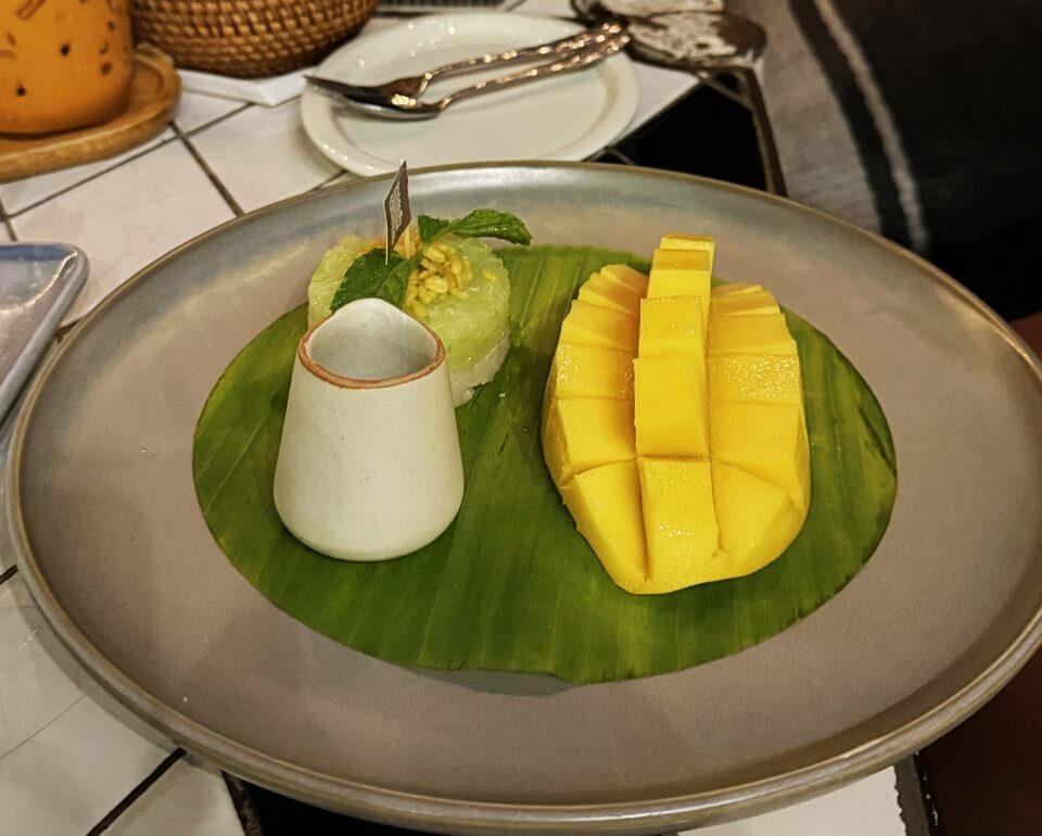 Mango Sticky Rice, Thai-Spezialität Mango Sticky Rice auf Bananenblatt serviert mit Kokosmilch in einem Restaurant in Pattaya