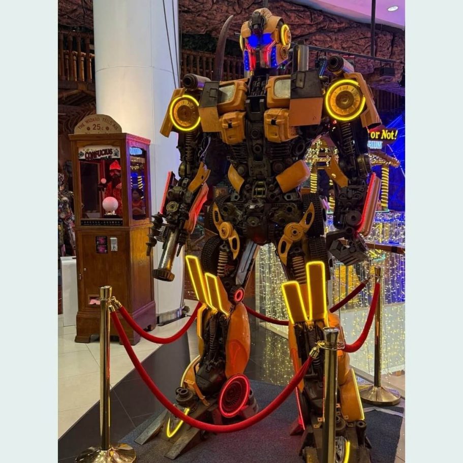 Thailändische Recycling-Kunst: Autoschrottroboter in Pattaya Imposante Transformers-ähnliche Roboterskulptur aus recycelten Autoteilen in goldenen und schwarzen Farbtönen