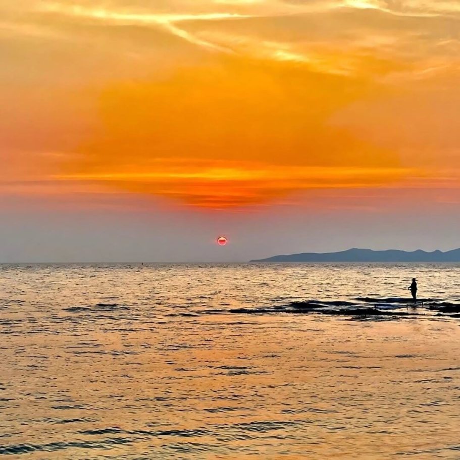 Strandruhe während des COVID-Stillstands Sonnenuntergang am Strand von Pattaya mit orangefarbenem Himmel und einsamer Silhouette während der COVID-Zeit